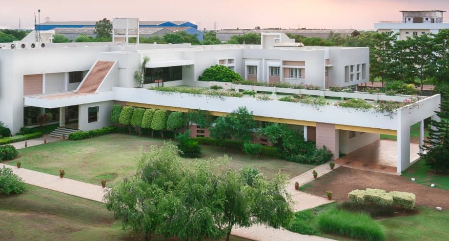 The Gnanam School of Business campus: white buildings with rooftop gardens, lawns and walkways